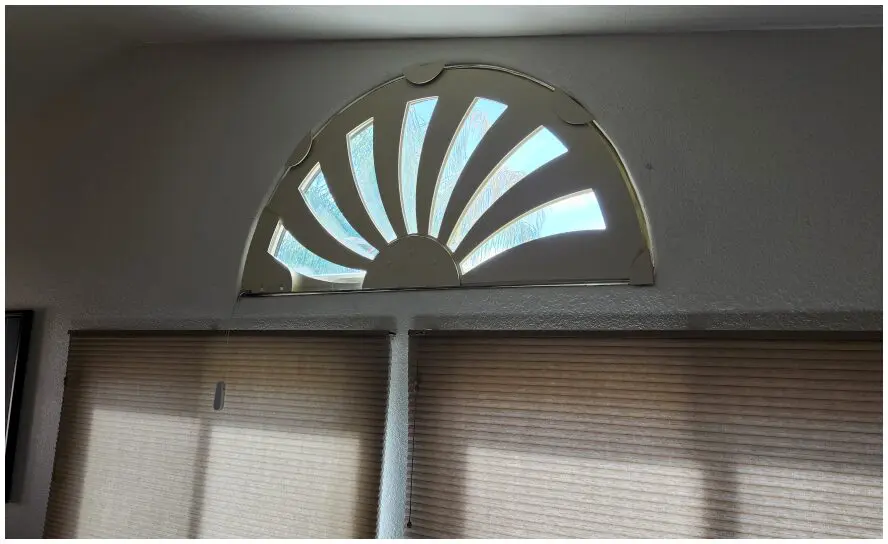 Arched window with decorative sunburst design.